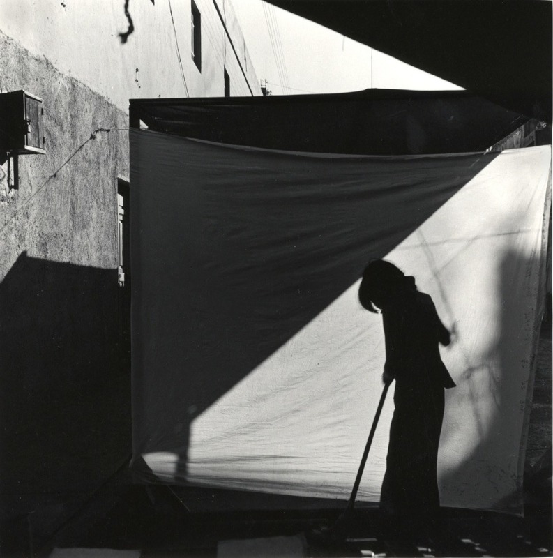 A woman's silhouette is shown sweeping in this black and white photo.