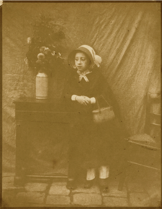 An old sepia photograph portrait of a woman wearing a bonnet