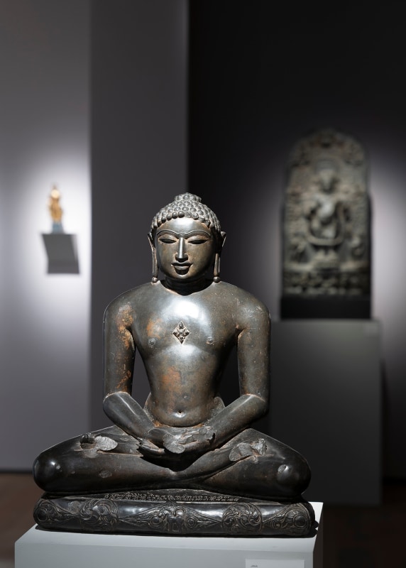 This elegant and highly-polished black stone figure of a jina is a superlative example of 11th-century Jain sculpture