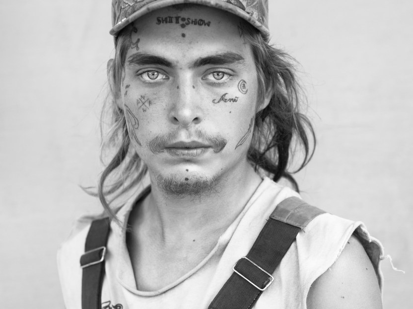 Man with face tattoo and hat by Michael Joseph