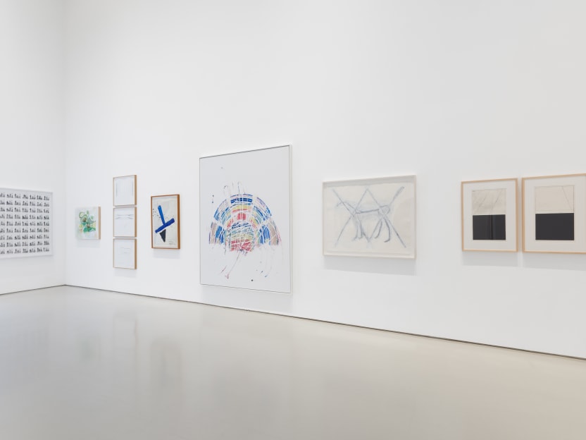 corner of gallery pictured with framed artworks of various sizes on the wall