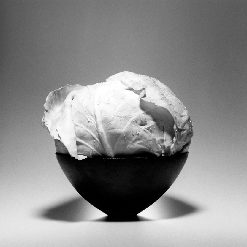 Head of cabbage in elegant black bowl.