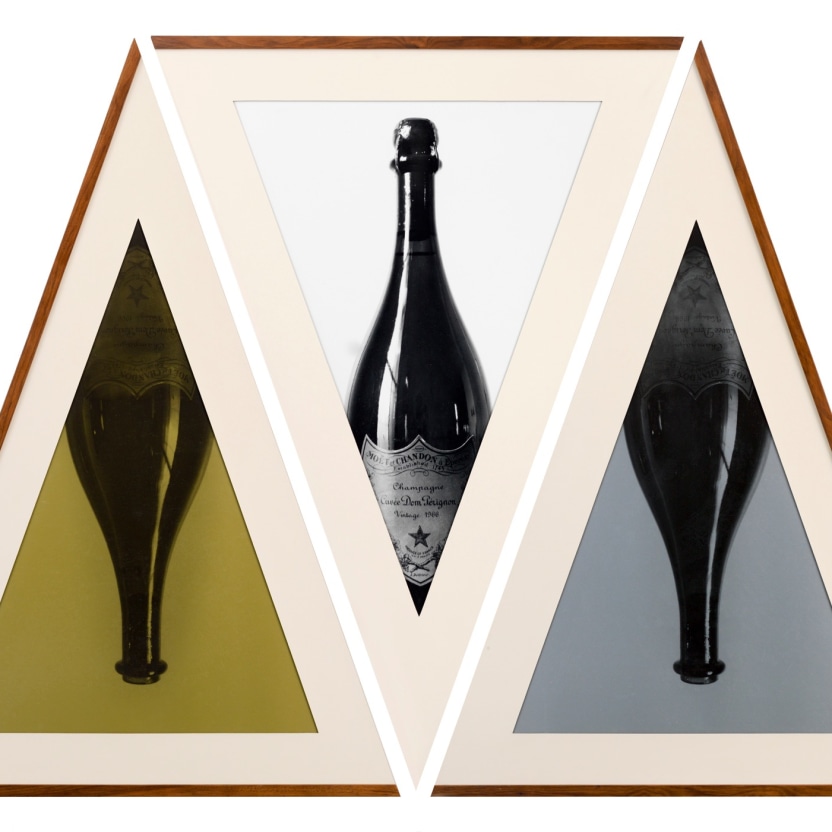 Geometric triptych of champagne bottles in triangular frames.