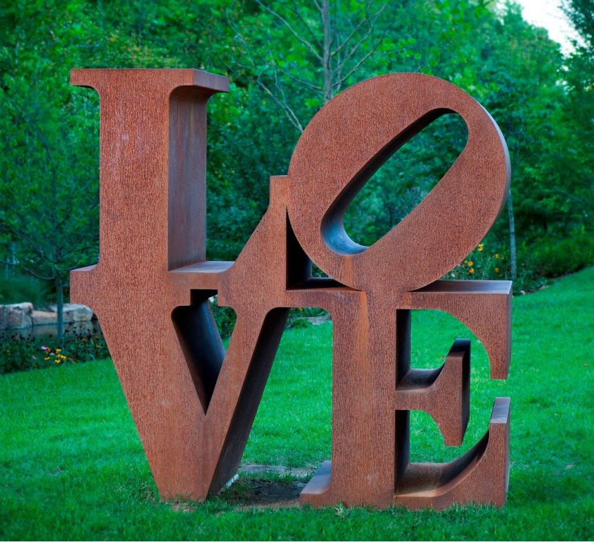 Corten LOVE sculpture with the letter L and a tilted letter O on top of the letters V and E.