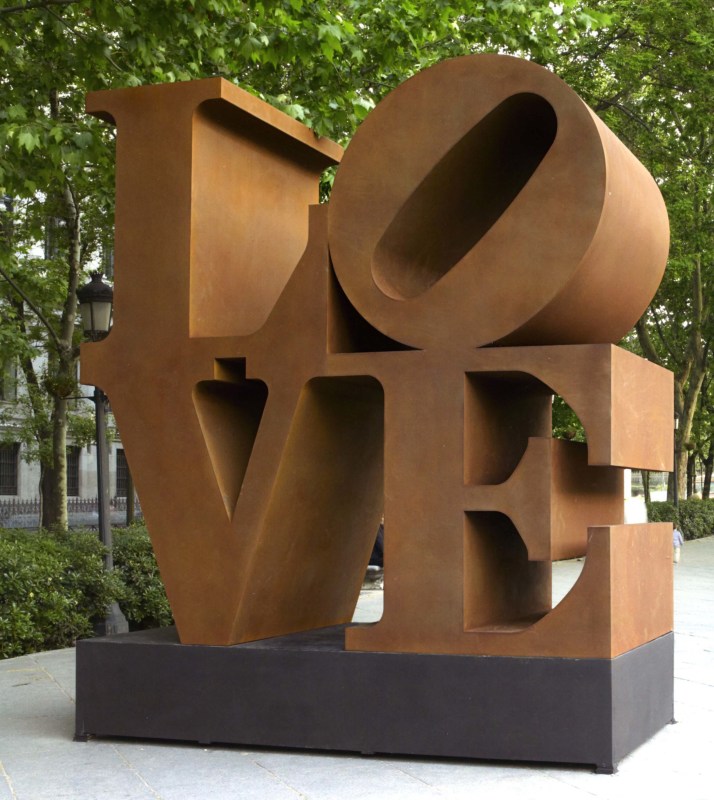 Corten LOVE sculpture with the letter L and a tilted letter O on top of the letters V and E.