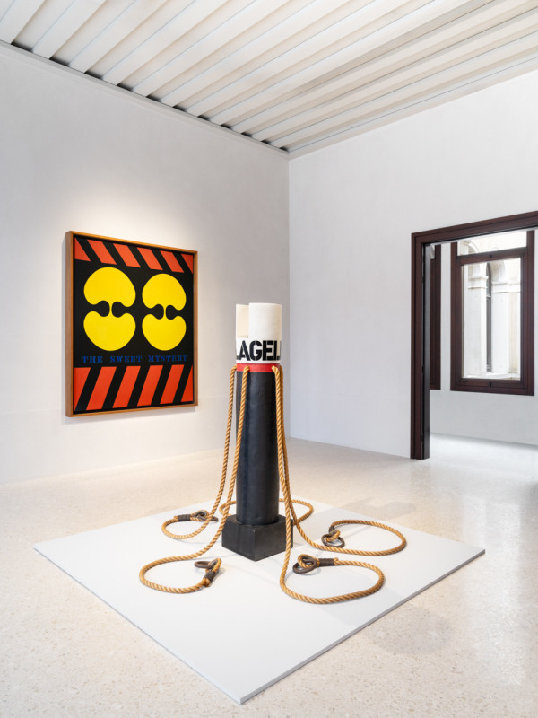 Installation view of Robert Indiana: Sweet Mystery featuring the painting The Sweet Mystery and the sculpture Flagellant