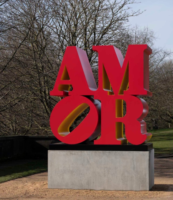 Robert Indiana's Red Yellow polychrome aluminum AMOR sculpture on display in the Yorkshire Sculpture Park