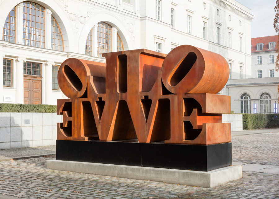 A Cor-Ten steel sculpture consisting of two quadripartite LOVE sculptures side by side, with the L and V of each sculpture back to back and the O and E facing outwards. 