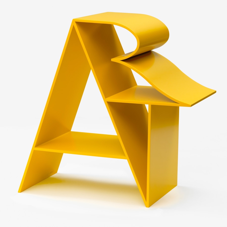 Art is an 18 by 18 by 9 inch yellow polychrome aluminum sculpture. The letter "A” forms a supporting structure that the “R” and “T” lean against.