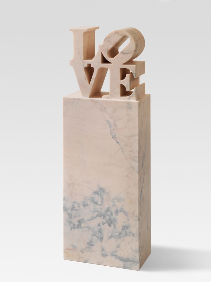 LOVE, a 65 15/16 × 22 1/8 × 12 5/16 inch, including the base, pink marble sculpture with the letters L and a tilted O stacked above the letters V and E, atop a tall rectangular base.
