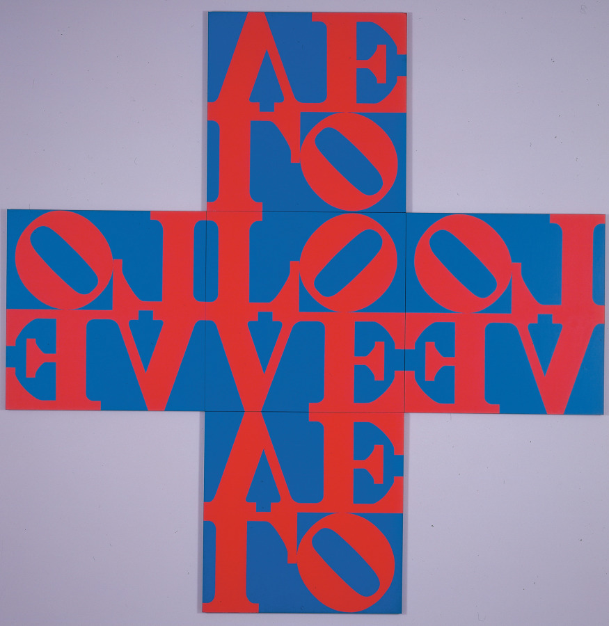 A cross shaped painting consisting of five identical LOVE panels. Each panel consists of a red letter L and a tilted red O over the red letters V and E, against a blue ground. The O of the central panel faces right, the panels to left and right of the central panel are hung so that the O faces to the left. Both the top and bottom panels of the cross are hung upside down, so that the O faces to the right.