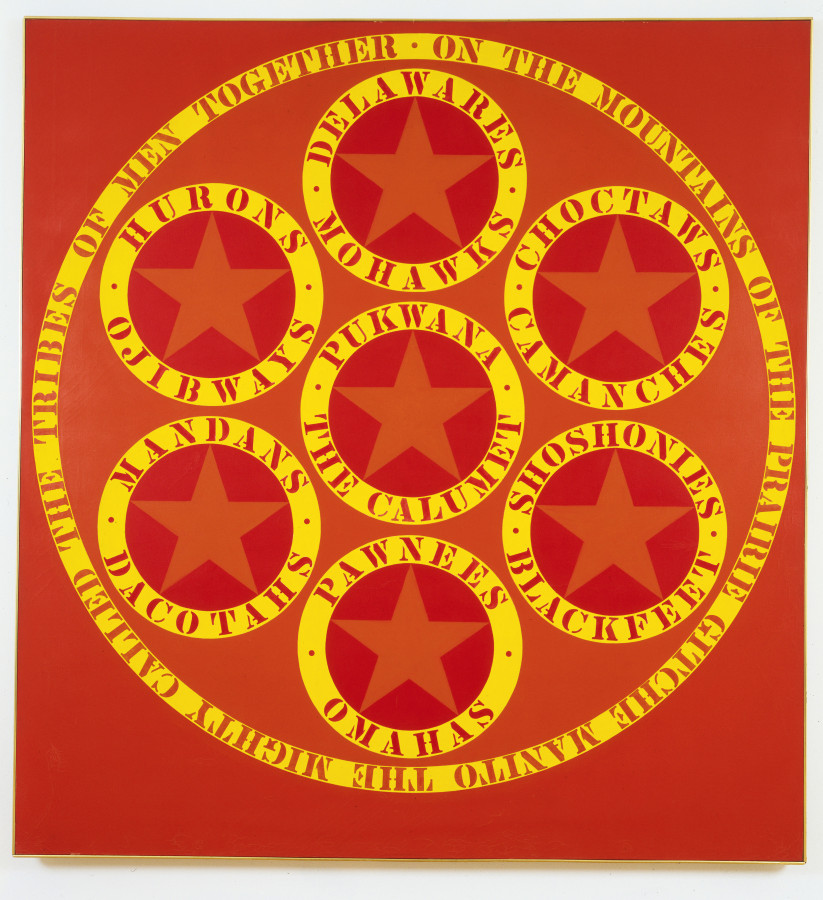 A painting with a large circle containing seven smaller. The seven smaller circles each hold an orange star, and are surrounded by the names of different Native American tribes painted in red stenciled letters in an outer yellow ring.  A yellow ring encloses the large circle, and contains the red stenciled text "On the mountains of the prairie Gitche Manito the mighty called the tribes of men together."