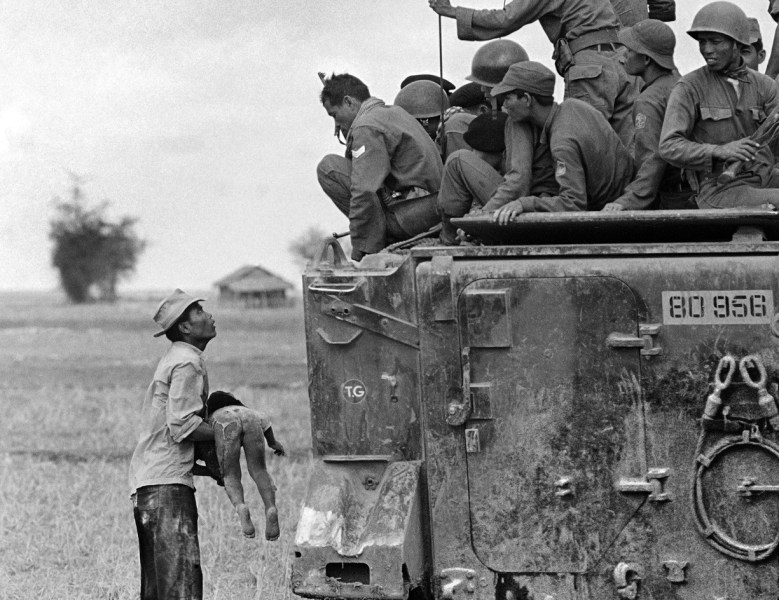 Horst Faas- A Distraught Father Holds the Body of his Child as South Vietnamese Rangers Look Down from their Armored Vehicle