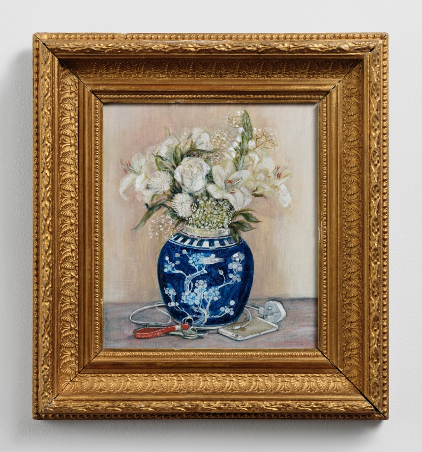 Still life of a vase of flowers with an iPhone and a charger