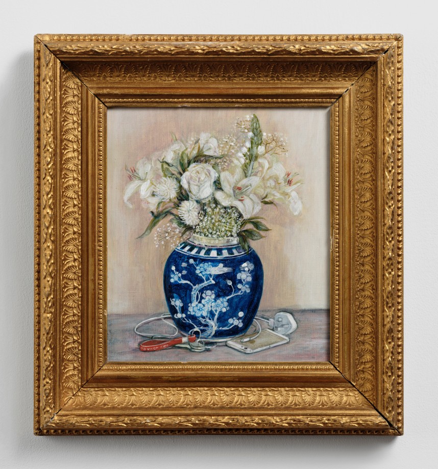 Still life of flowers in a blue and white vase with a usb charger