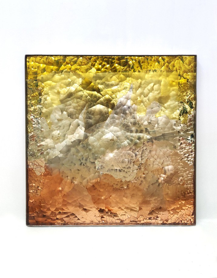 Reflective yellow, silver and brown tone of colored of blown mirrored glass from top to bottom in the square frame