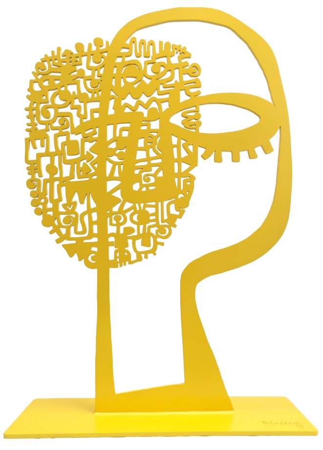 Yellow metal sculpture of an abstract face