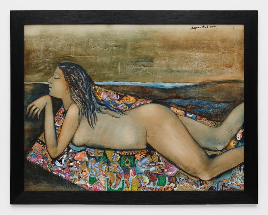 A nude woman lying on her stomach on a multicoloured blanket on the beach