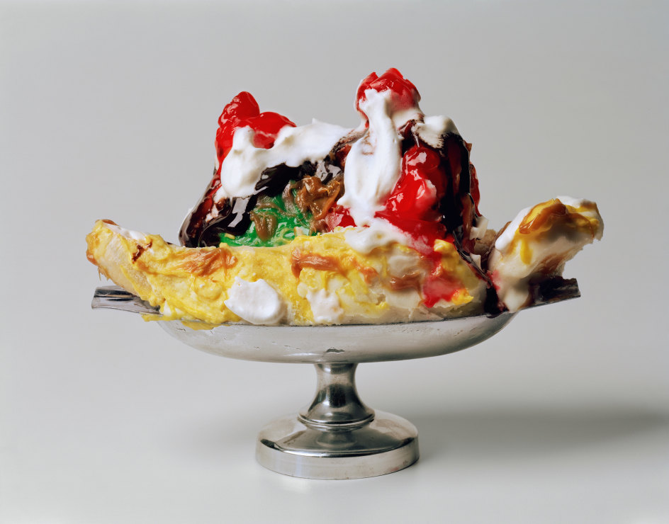 Photograph by Sharon Core of a banana split sundae in a silver dish arranged to look like the sculpture by Claes Oldenburg.