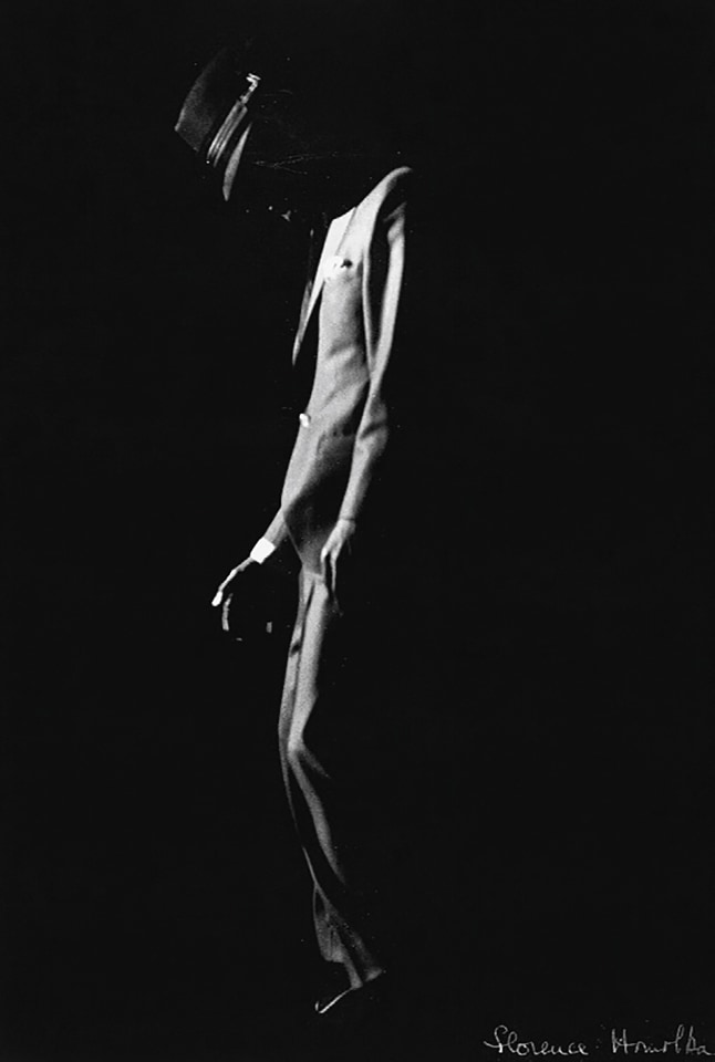 Florence Homolka, Sammy Davis, Jr., ​c. 1950. Subject faces left with head down on a dark stage.