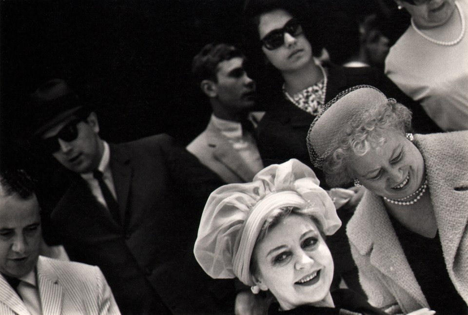 27. Donald Blumberg, In Front of St. Patrick's Cathedral, ​1965. A crowd featuring four women and three men fill the lower diagonal right two-thirds of the otherwise black frame.