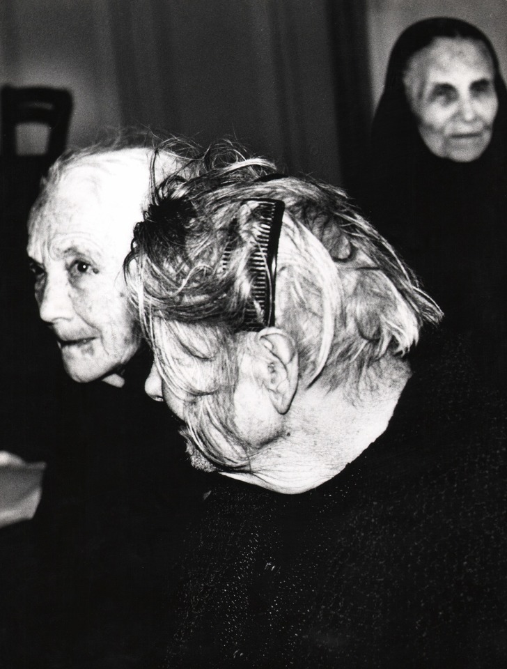 29. Mario Giacomelli, Verr&agrave; la morte e avr&agrave; i tuoi occhi, 1966&ndash;1968. High contrast image. Old woman with a comb in her hair in left-facing profile. Two other women are seen behind her.