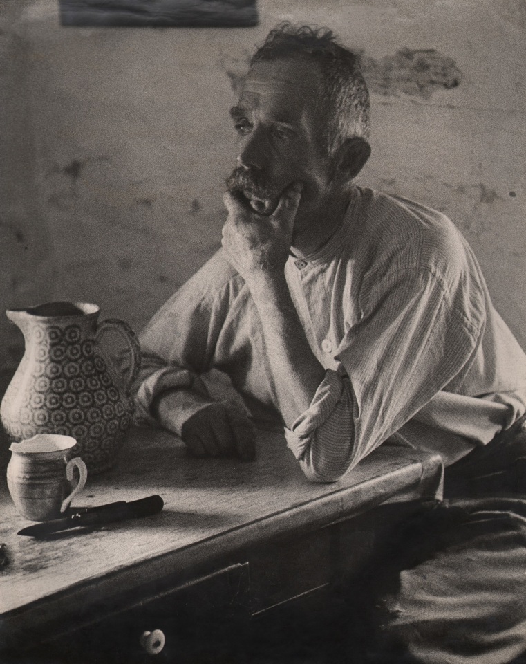 43. Felix H. Man, Unemployed, c. 1955. A man sits at a table set with a pitcher and mug, one hand to his face, gazing to the left of the frame.