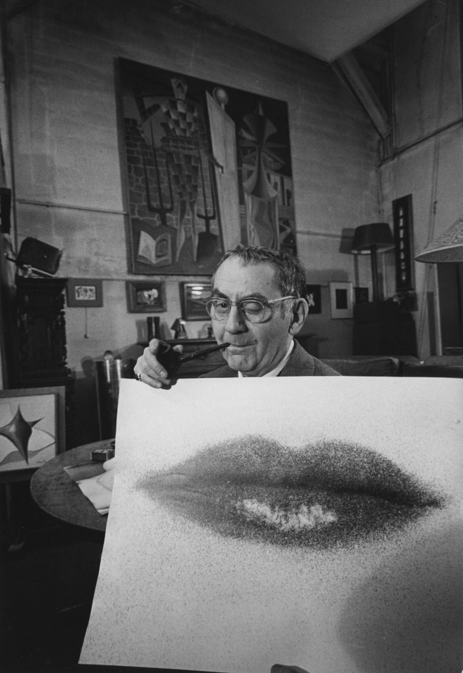 29. Loomis Dean (American, 1917-2005),&nbsp;Man Ray with photograph of Lee Miller&#039;s lips (for Life Magazine), Gelatin Silver Print, 13.25&rdquo; x 9&rdquo;