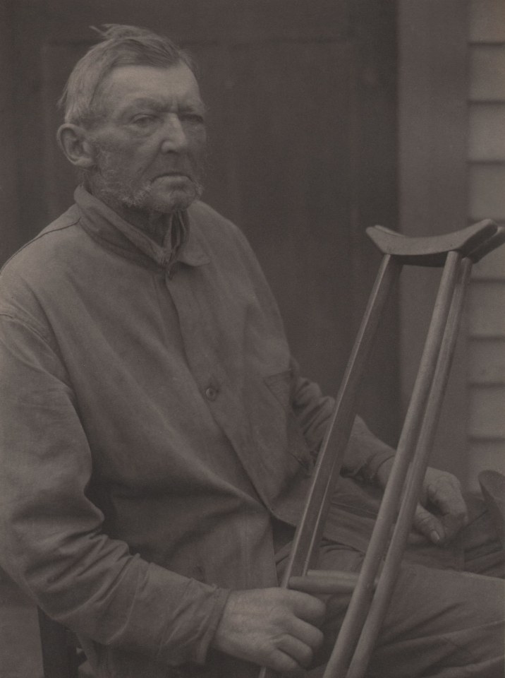 Doris Ulmann, Untitled (War veteran), ​1928&ndash;1934. Seated man holding crutches in front of him with his right hand looks to the right of the frame.