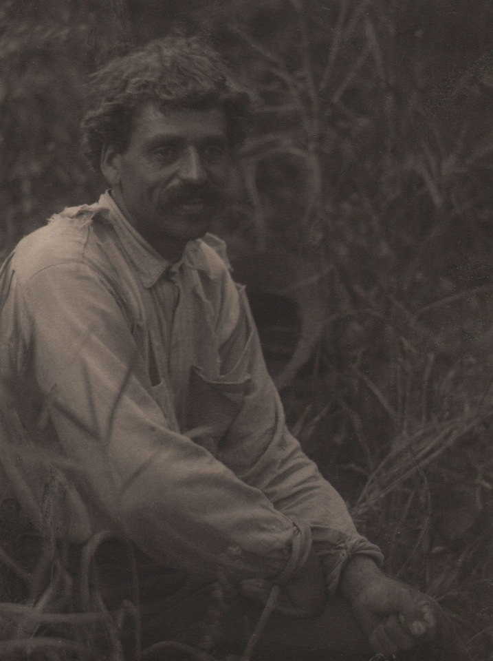 Doris Ulmann, Untitled (Farmer), ​1928&ndash;1934. Man seated outdoors among tall grass in the left of the frame looking slightly to the right of the frame.