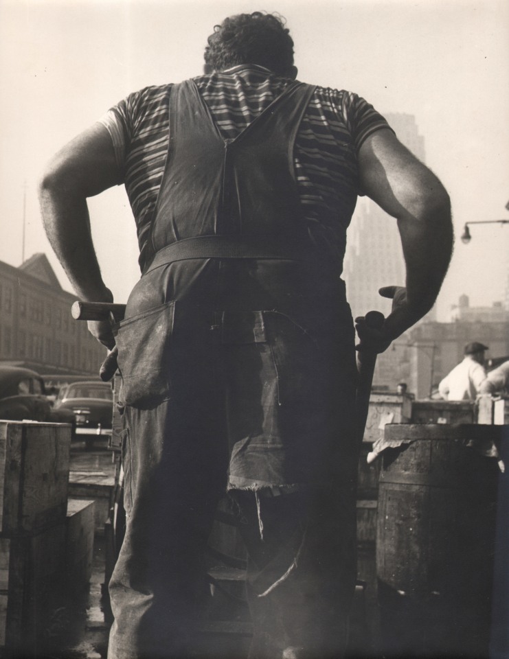 11B. Simpson Kalisher, Untitled, ​1949. Rear view of a tall man in overalls and a tool belt.