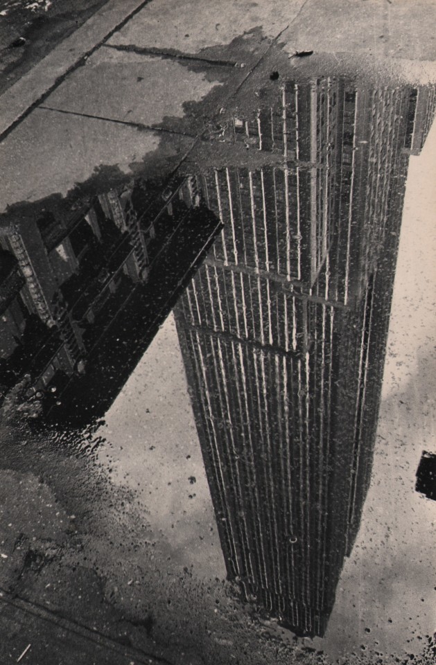 29. Fritz Neugass, Reflections: Empire State Building in a Rain Puddle, c. 1948. Upside-down reflection of the Empire State Building, imaged in a sidewalk puddle.