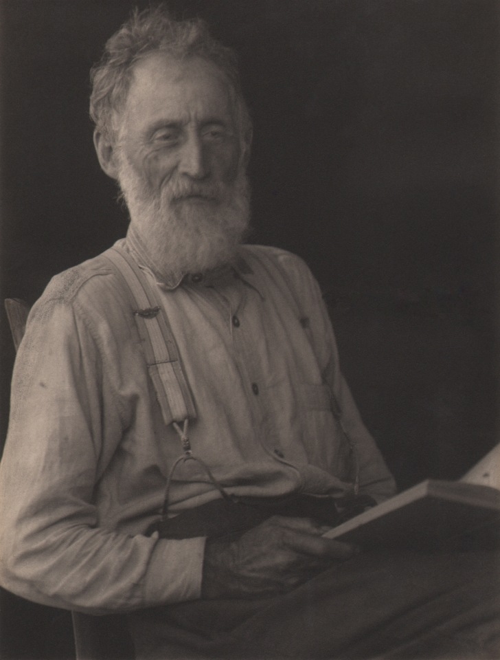 Doris Ulmann, Untitled (Appalachian man), ​1928&ndash;1934. Older bearded man in suspenders, seated and holding a book in his lap.