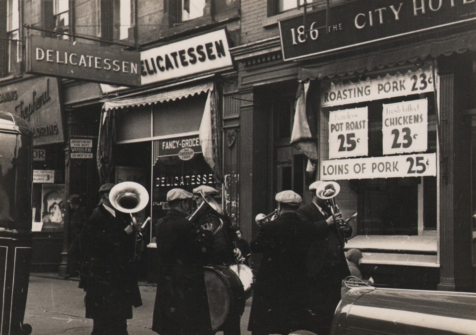 12. Arthur Rothstein, Unemployed Musicians, New York City, ​c. 1935. Group of five men holding instruments stand outside of a deli.