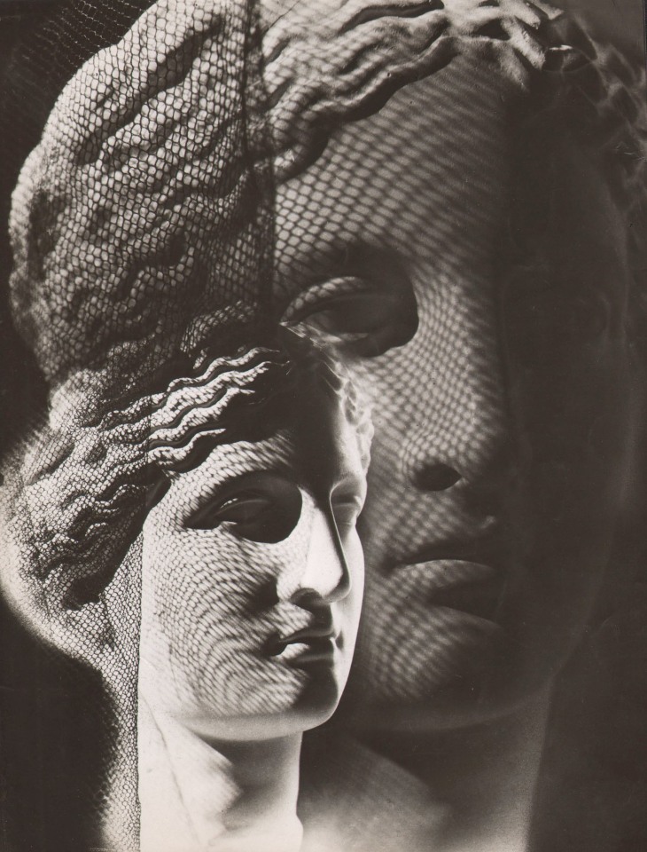 Claude Tolmer, Composition, ​1936. Marble sculpture of a woman's head in two overlapping views. Mesh netting casts a shadow.