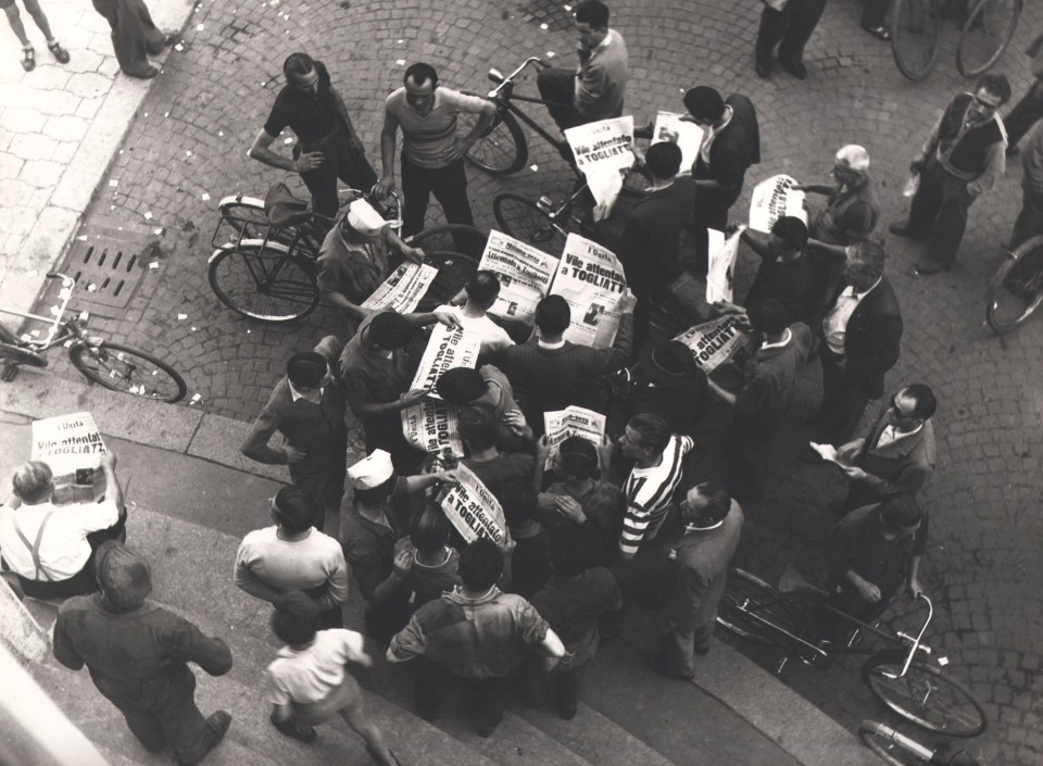 Giancolombo, Milano, Vile attentato a Togliatti, 1948. Street scene photographed from above. A crowd of men gathers, many holding newspapers with the headline &quot;Vile attentato a Togliatti&quot;