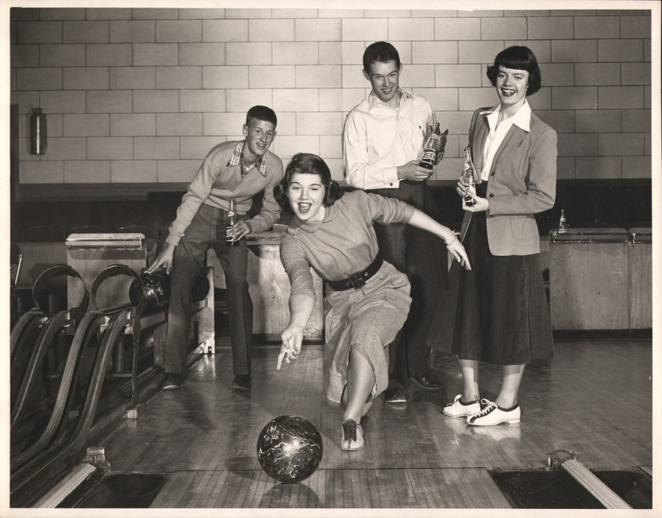 Ralph Bartholomew, Pepsi-Cola, ​1950. A teenager bowling while three other teens look on from behind holding glass bottles of Pepsi.