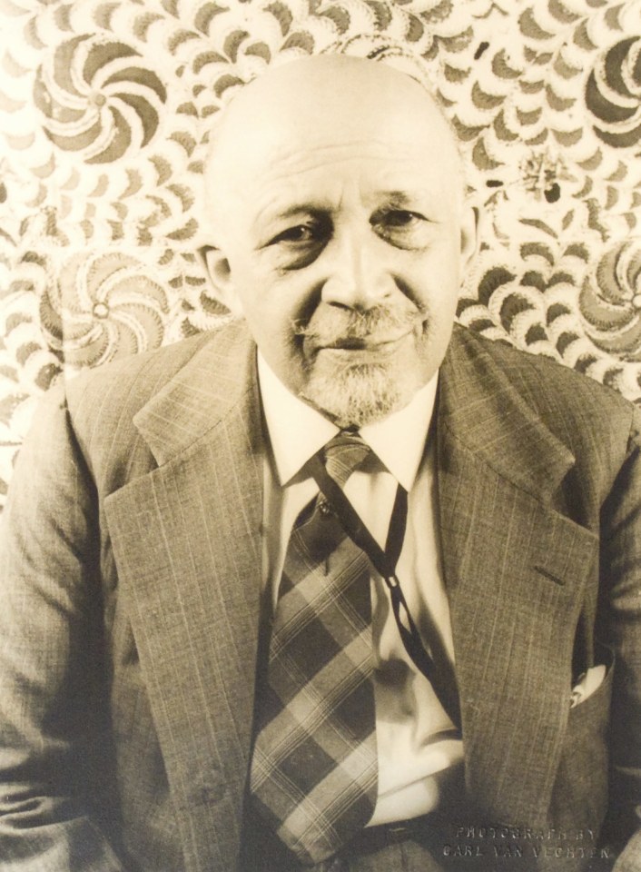 25. Carl Van Vechten, W.E.B. Du Bois, 1946. Bust-length portrait of subject smiling to the camera in a jacket and tie.