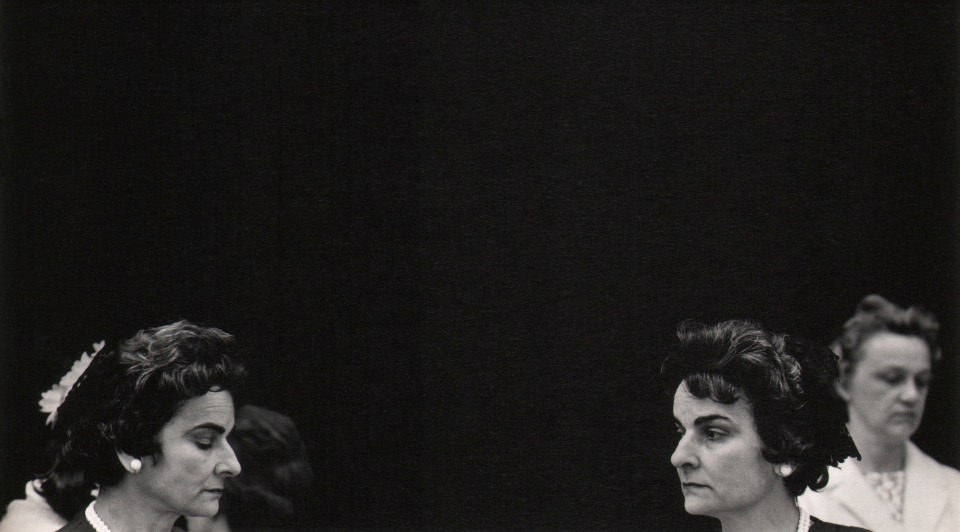 25. Donald Blumberg, In Front of St. Patrick's Cathedral, ​1965. The heads of three women are seen in the lower third of the otherwise black frame.