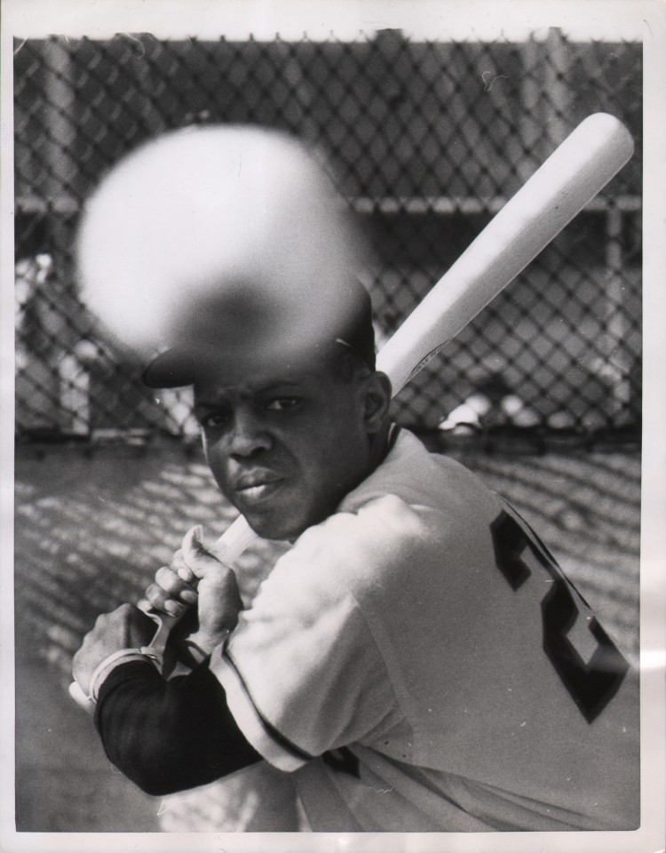 United Press Photo, A Pitcher of Willie, ​1958. Subject holds his baseball bat at the ready as a baseball (out of focus in the foreground) flies toward him.