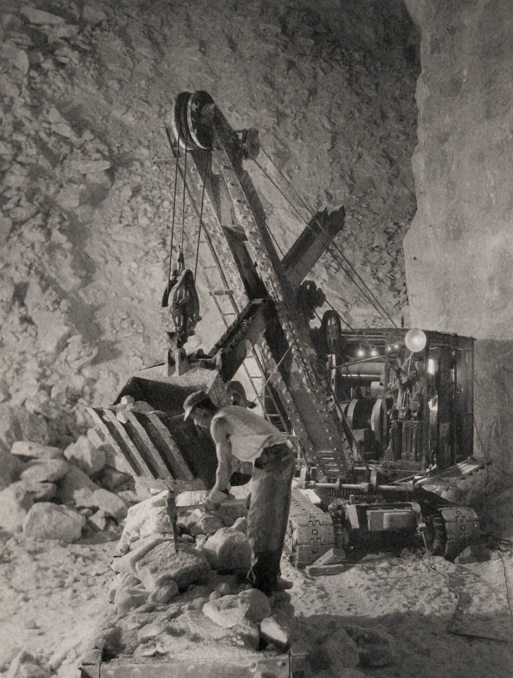 Harold Haliday Costain, After the Dynamite, Avery Island, Louisiana, ​1934. A worker wields a pickaxe in front of an excavating machine.