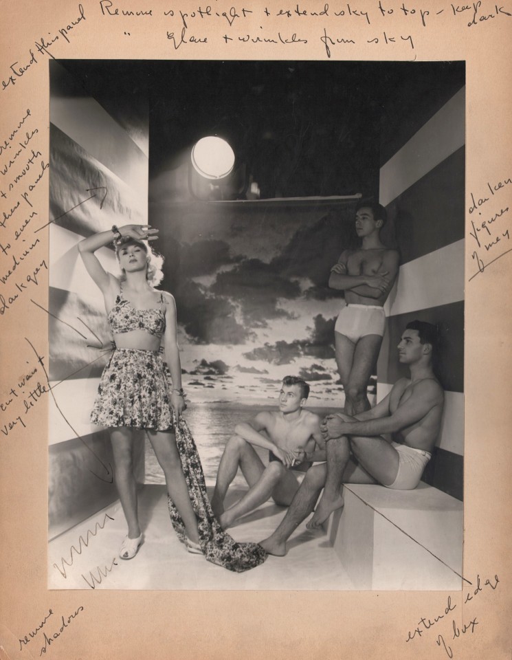 George Platt Lynes, Swimsuit Advertising, ​c. 1950. One female and three male models pose in swimsuits in a studio with a seascape backdrop. The artist's handwritten notes surround the print.