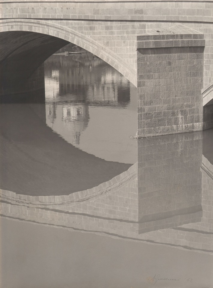 Alberto Galducci, Untitled, ​1952. Detail of an arched bridge and its reflection on a still body of water.