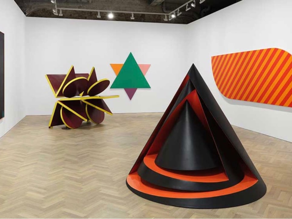 Art gallery installation of 2 geometric sculptures and 3 paintings