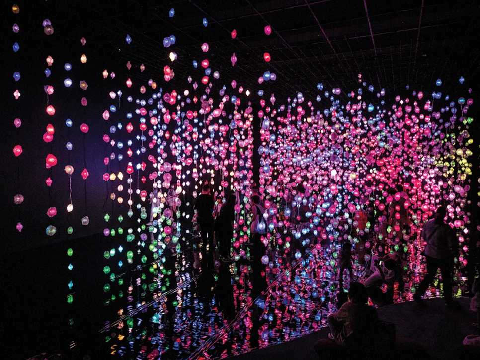 multicolored light strings hanging vertically in a darkened room