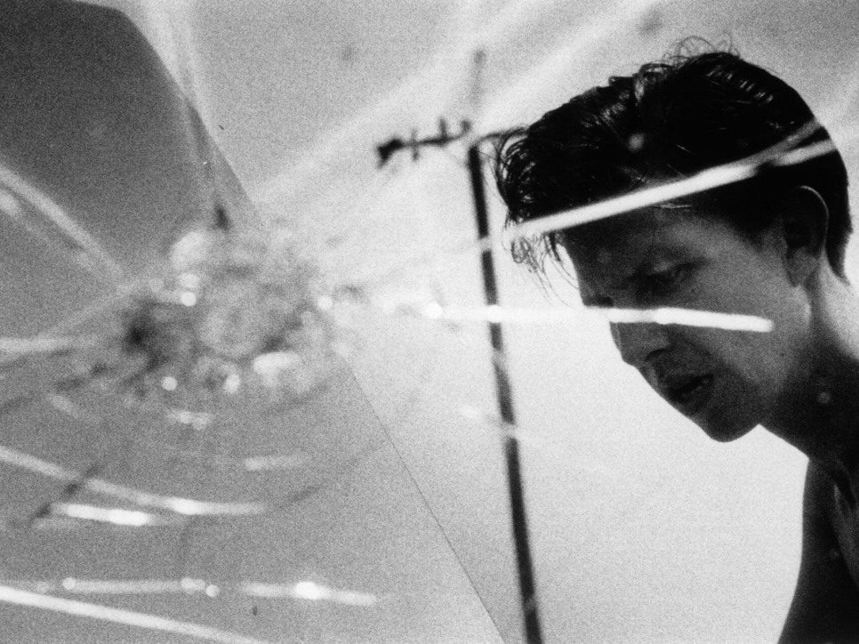 Photo of a  man, as seen through a cracked windshield
