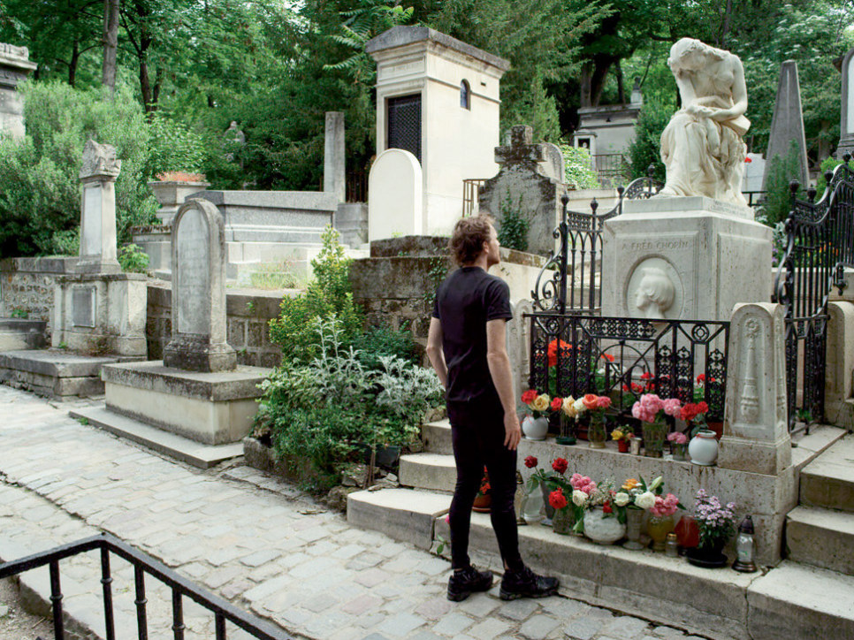 Man standing in front of grave