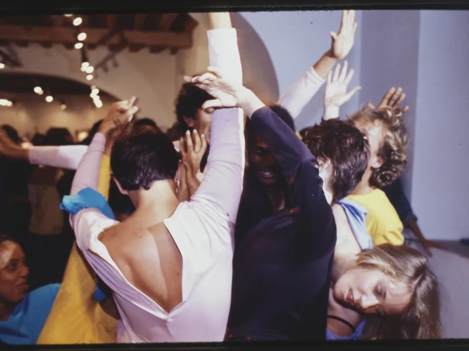 Close-up photograph of 7 dancers in various colored leotards