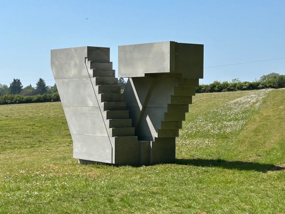 Concrete sculpture of stairs on a grassy field
