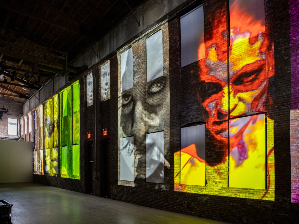video projection of faces on a brick wall